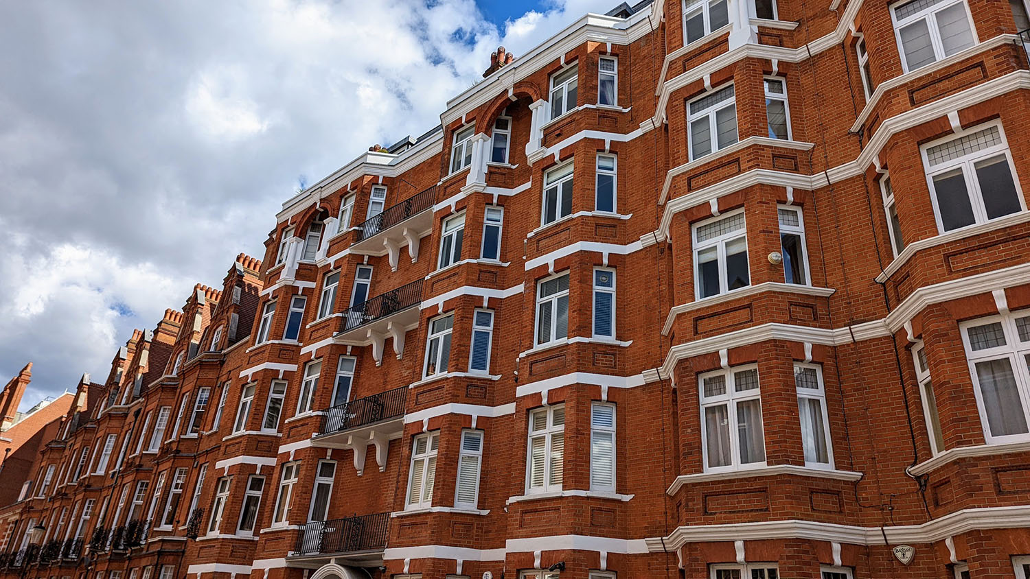 Red-brick Victorian mansion block with bay windows in central London, a building that needs block management